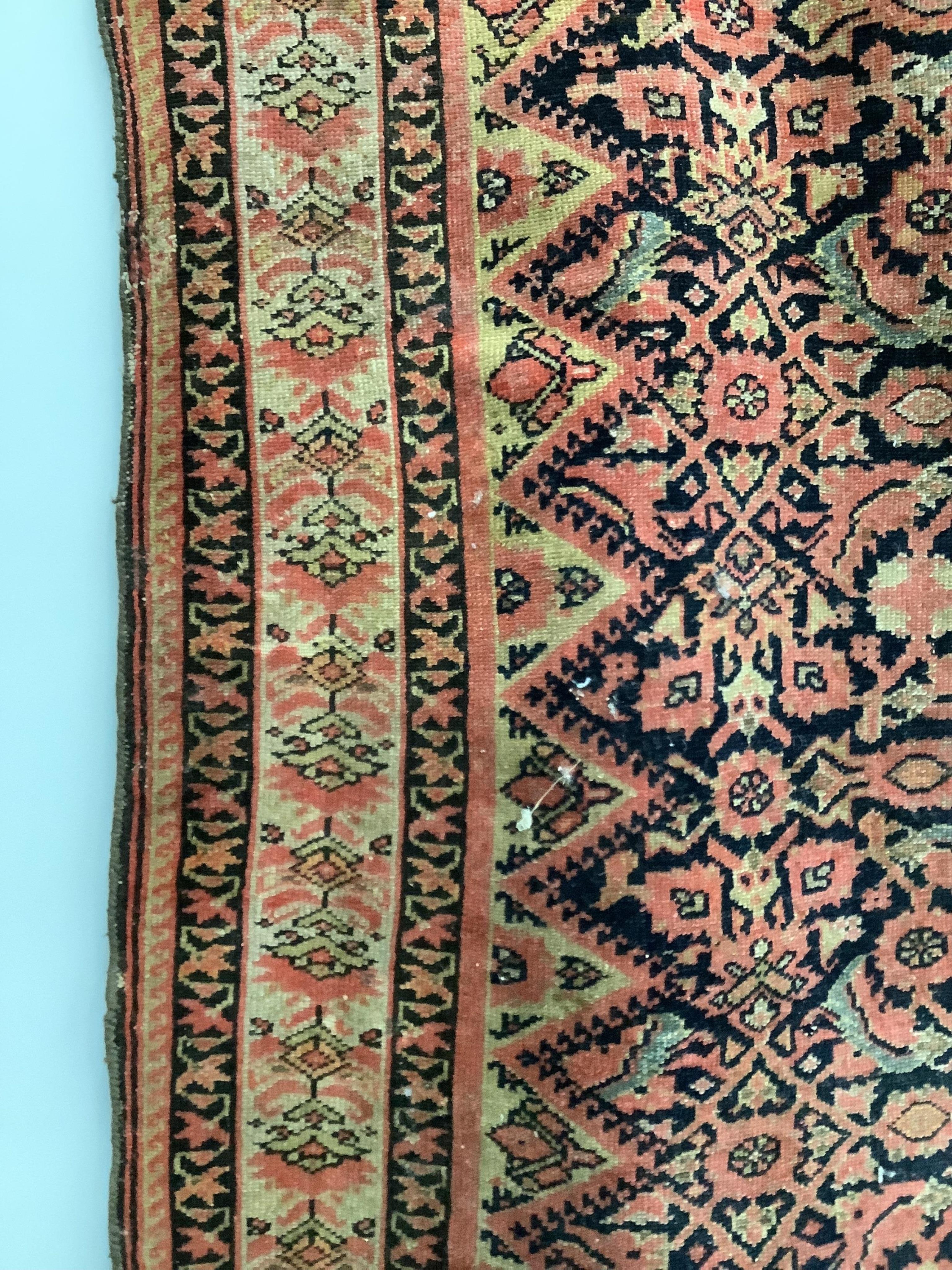 A Caucasian red ground rug, 192 x 129cm. Condition - faded and worn